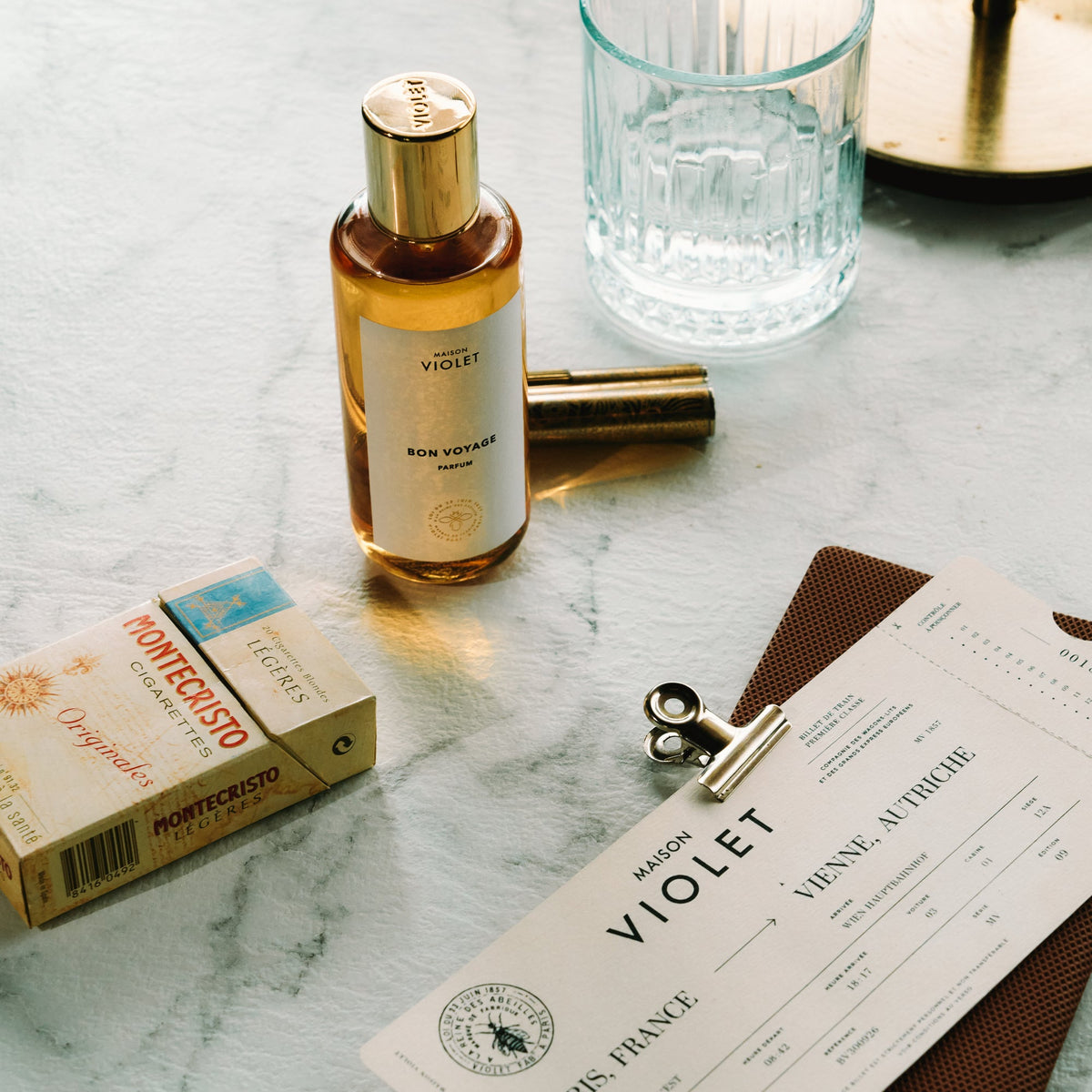 Maison Violet Bon Voyage with a train ticket and glass